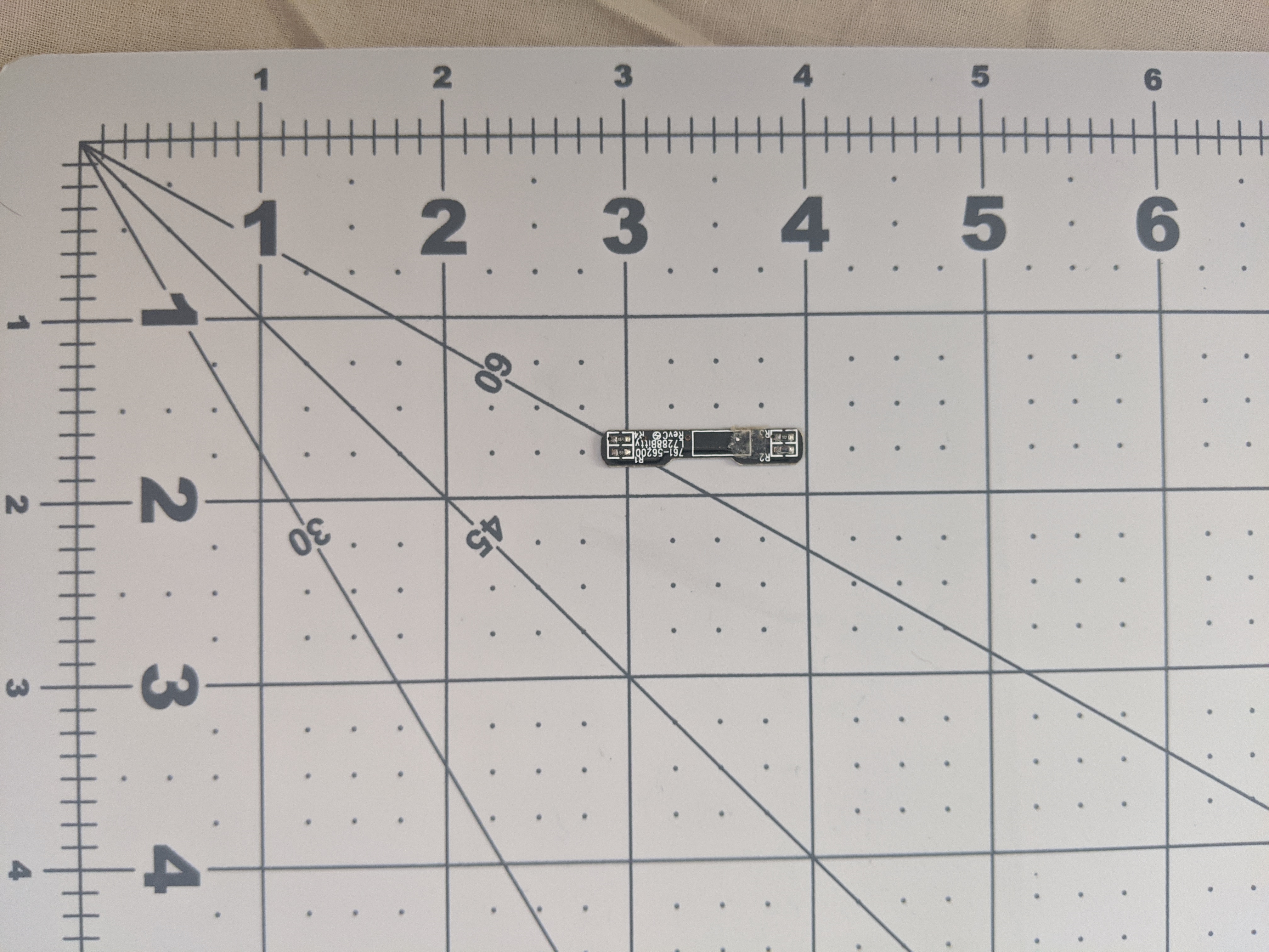 A PCB board taken from the normal sized Funkey. It's black, rectangular, and has surface mount resistors.